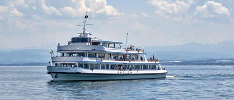 "MS Stuttgart" fährt auf dem Bodensee vor blauem Himmel.